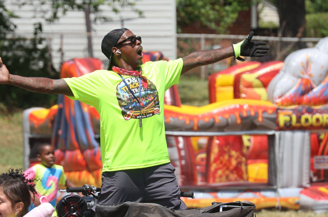 D&T host with arms wide open at a community event